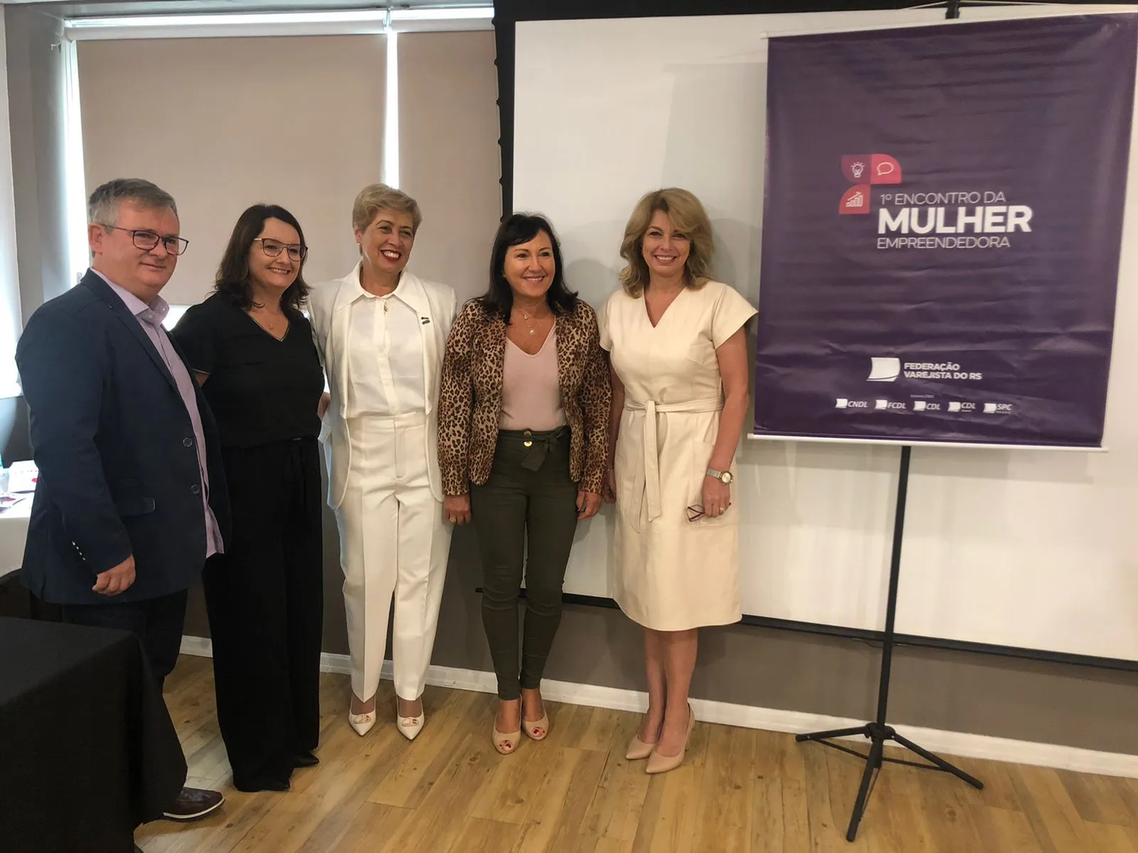 À esquerda, Ivonei Pioner, presidente da Federação Varejista do RS; Dione Pioner, esposa de Ivonei; vestindo branco, Lúcia Leijôto, coordenadora do Mulheres que Constroem o Varejo; Carmem Dalcin, coordenadora do NME de Caxias do Sul; e à direita, Débora Lunardi, diretora da Mulher Empreendedora do RS